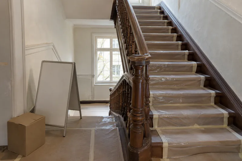 Dauer einer Badsanierung: Treppenhaus eines Altbaus mit abgedeckten Stufen während des Badumbaus